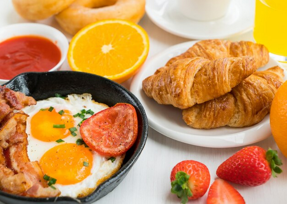croissant, eggs, bacons, tomatoes, lemon, and strawberries